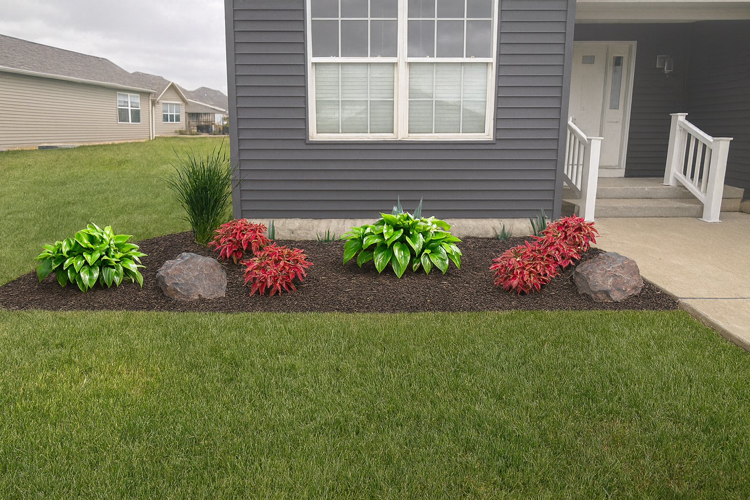 Foundation planting with hostas and coleus and accent stones.